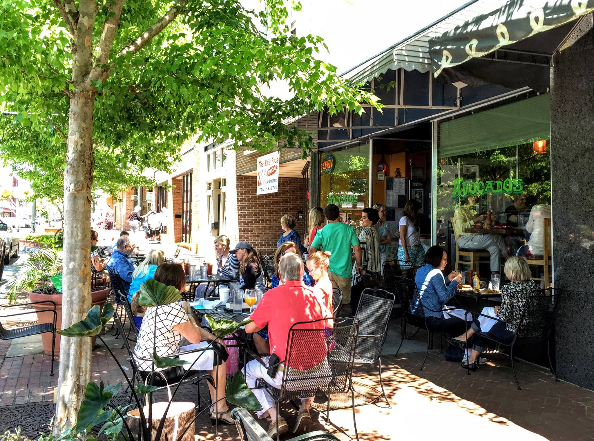 People eating outside of the Avocados restaurant on the Gainesville square