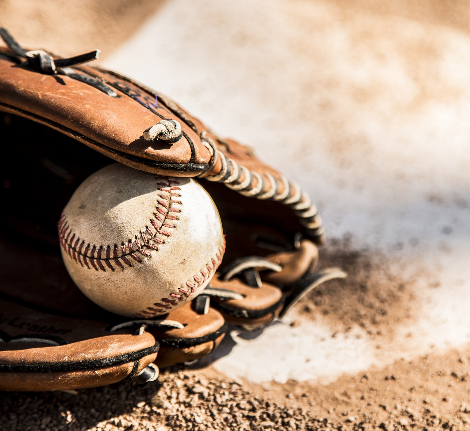 Baseball season is here.  Glove and ball on home plate.