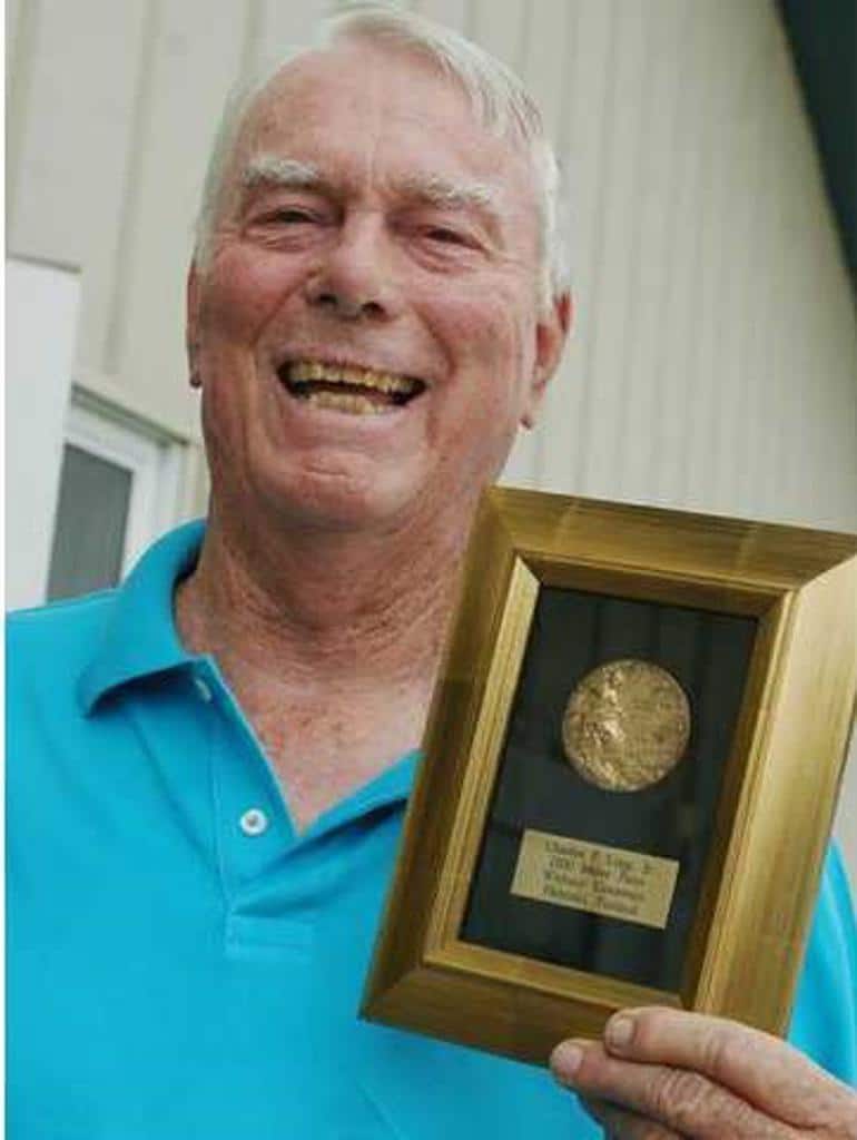 Logg posing for a picture while holding up an award