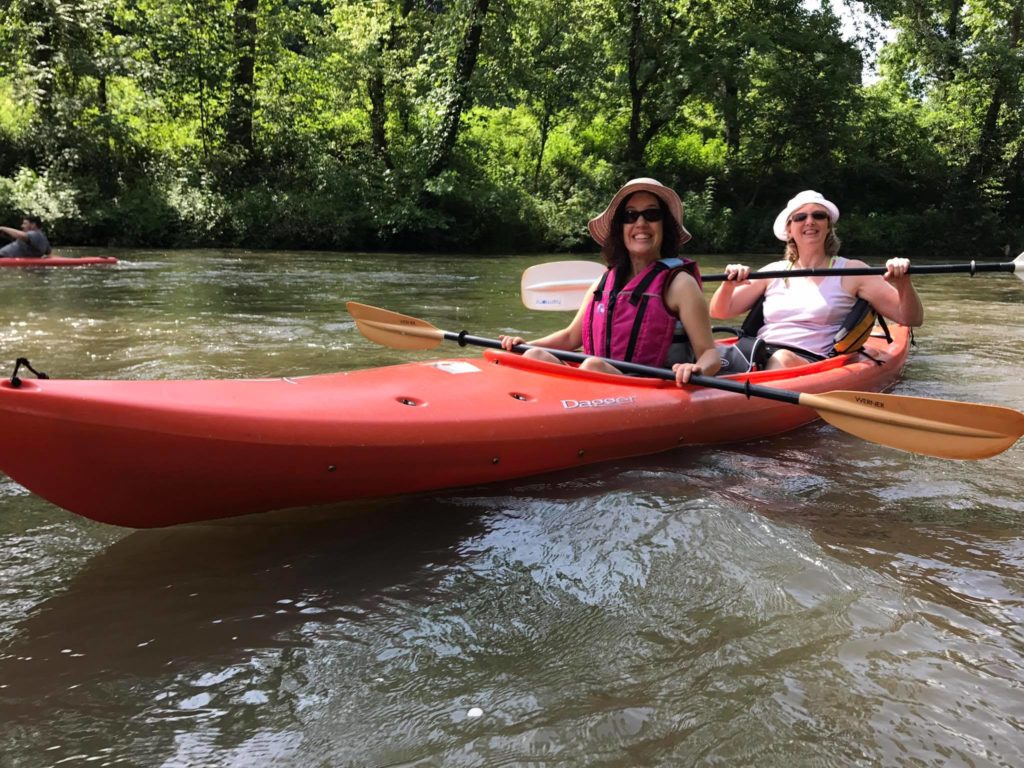 Two women kayaking on a river